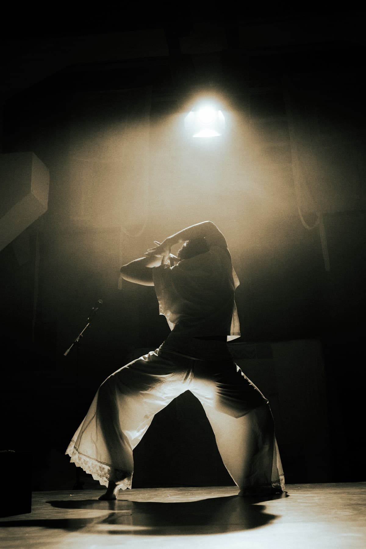 A dancer illuminated by stage light in a smoky room