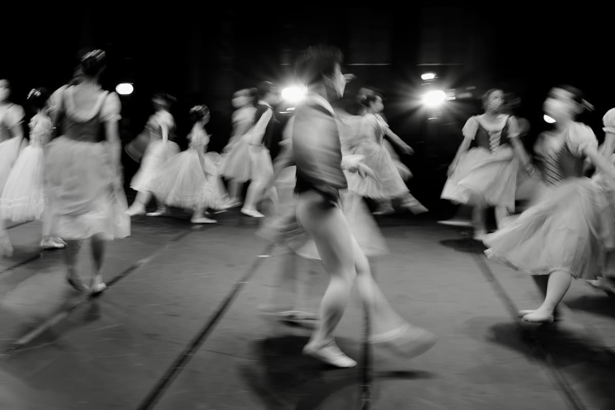 Ballet dancers in motion on a dark stage